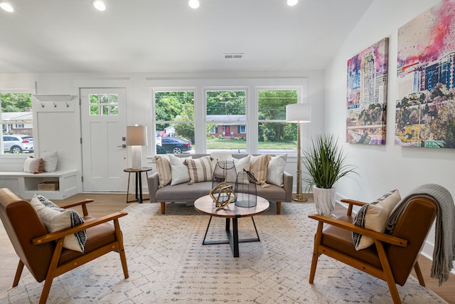 living room with two brown arm chairs and a large picture window with a view of a quiet suburban street